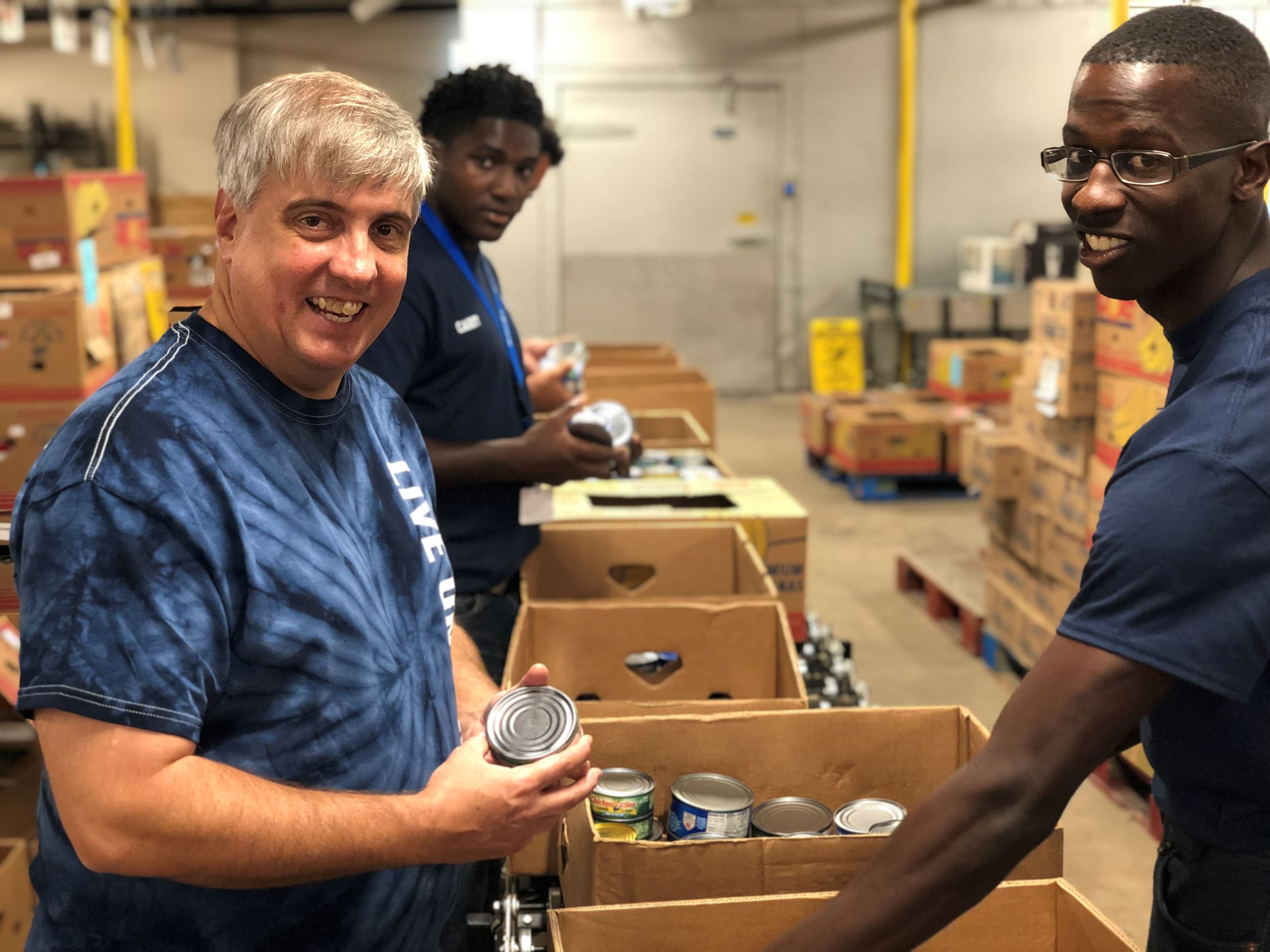 Mayor Grover Robinson and city staff sort cans at Manna Food Pantries