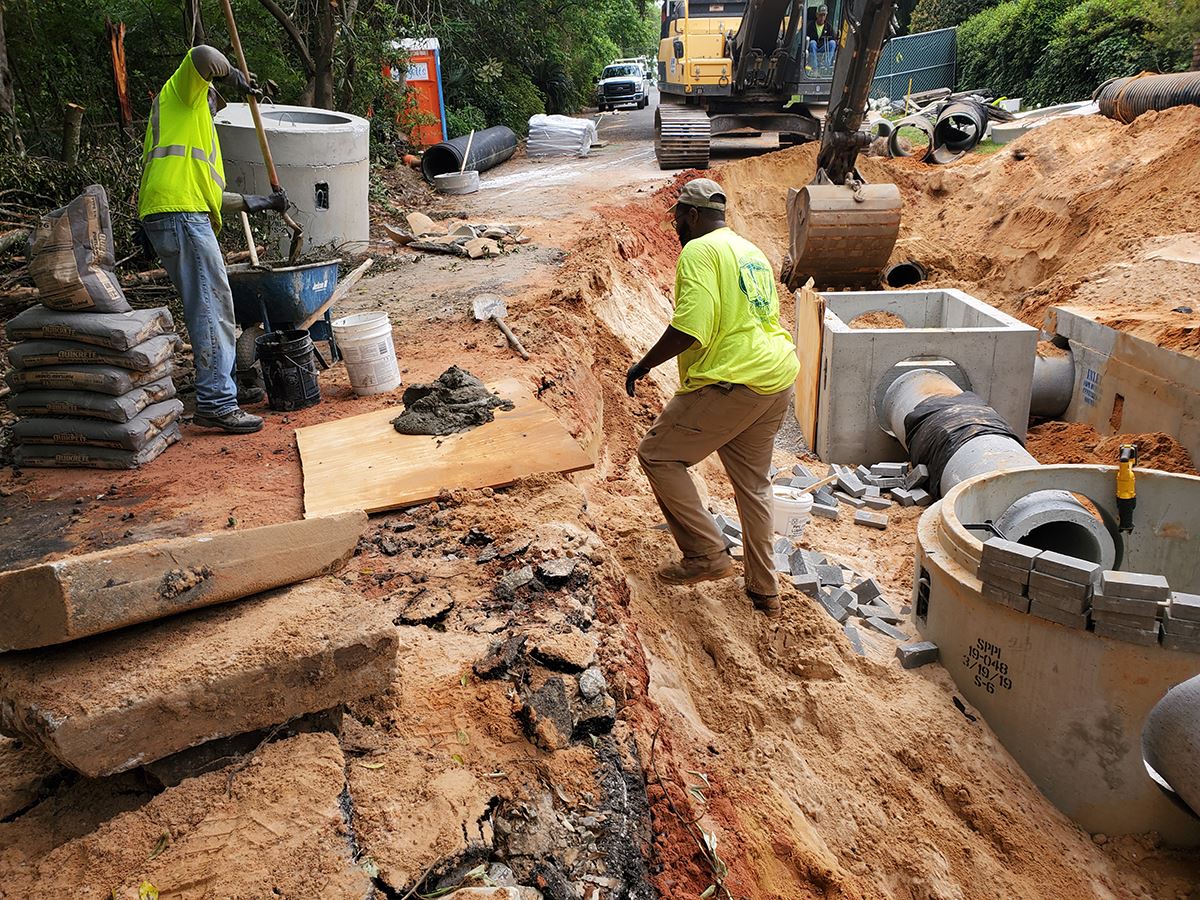 Construction workers install an underground stormwater treatment unit