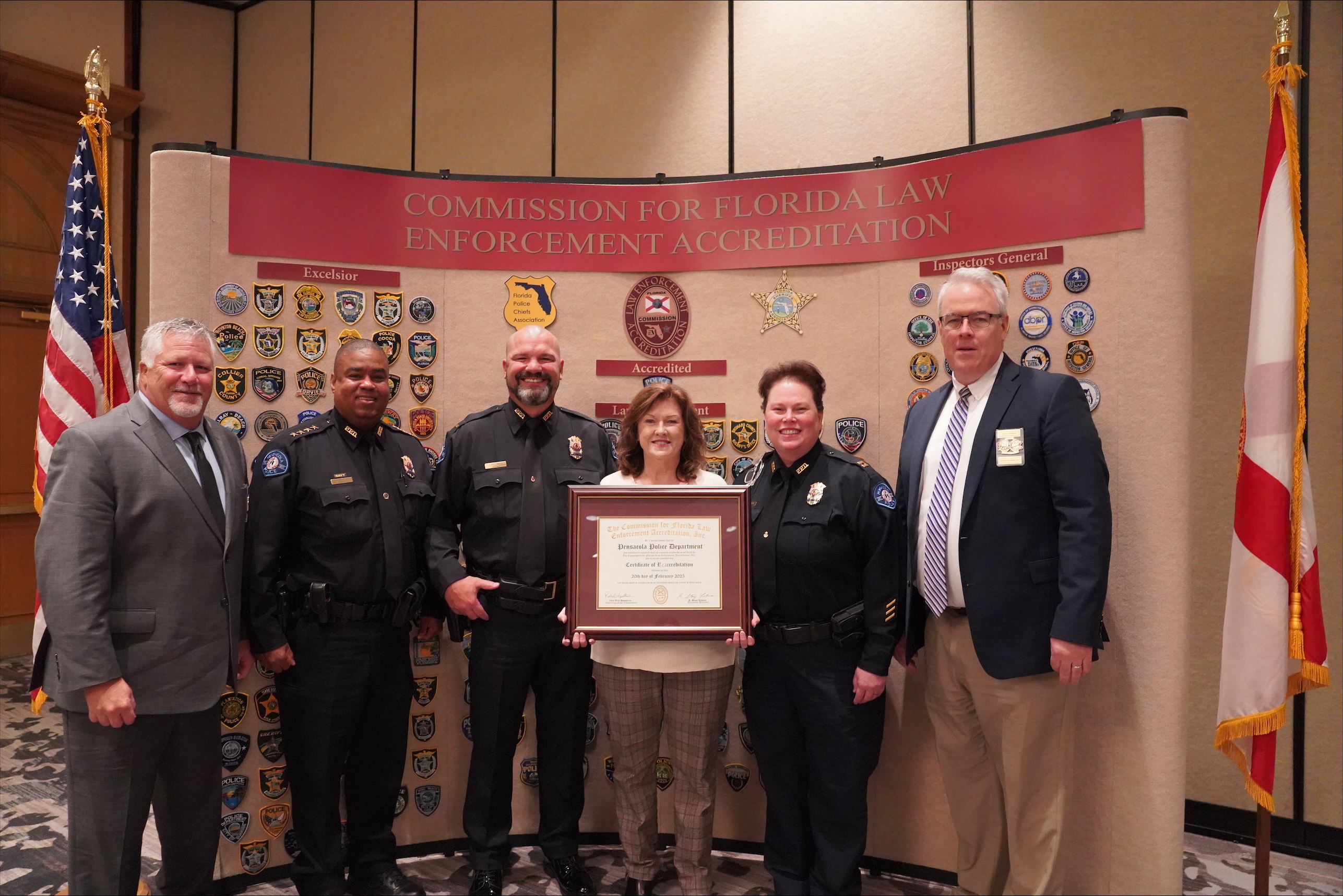 Members of PPD holding certificate of accreditation in front of wall